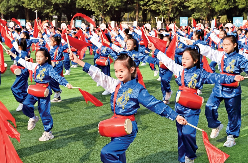 為助推民族地區(qū)基礎(chǔ)教育事業(yè)發(fā)展，廣西重新核定各地中小學(xué)教職工編制，依托全區(qū)編制“周轉(zhuǎn)池”核增事業(yè)編制給各地中小學(xué)，在全面達(dá)到國(guó)家標(biāo)準(zhǔn)的基礎(chǔ)上，進(jìn)一步統(tǒng)籌優(yōu)化和動(dòng)態(tài)調(diào)整各區(qū)域、學(xué)校、學(xué)段間編制資源。圖為2023年11月29日，南寧市濱湖路小學(xué)舉行主題為“逐夢(mèng)新時(shí)代 健體向未來(lái)”的體育文化節(jié)，孩子們正在跳腰鼓舞。 新華社記者 周華/攝
