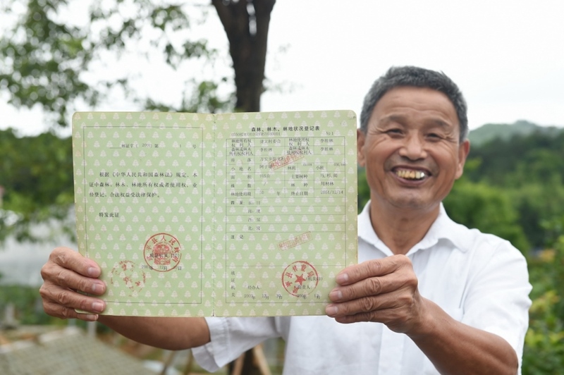 福建武平縣萬安鎮(zhèn)捷文村村民李桂林展示林權改革后領到的全國第一本新式林權證。