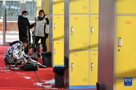 12月21日，游客在滑雪服務(wù)大廳整理滑雪裝備。