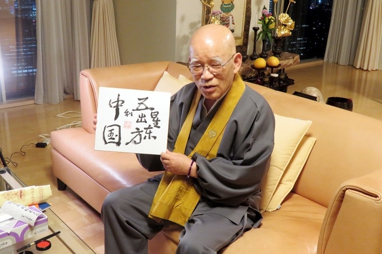 小島康譽展示自己書寫的“五星出東方利中國”。視頻截圖