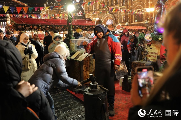 游客在新年集市上體驗(yàn)制作紀(jì)念幣。人民網(wǎng)記者 隋鑫攝