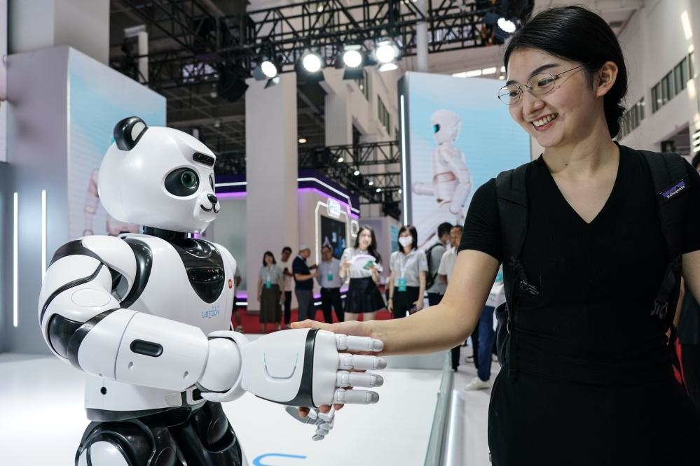 2023年8月16日，一名女士在北京舉辦的2023世界機器人大會現(xiàn)場與智能機器人握手。新華社記者彭子洋攝
