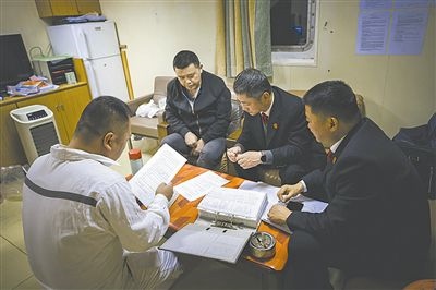 圖②：法官向船長講解相關法律規(guī)定，查看船舶資料，并與船方辦理扣押船舶的手續(xù)。