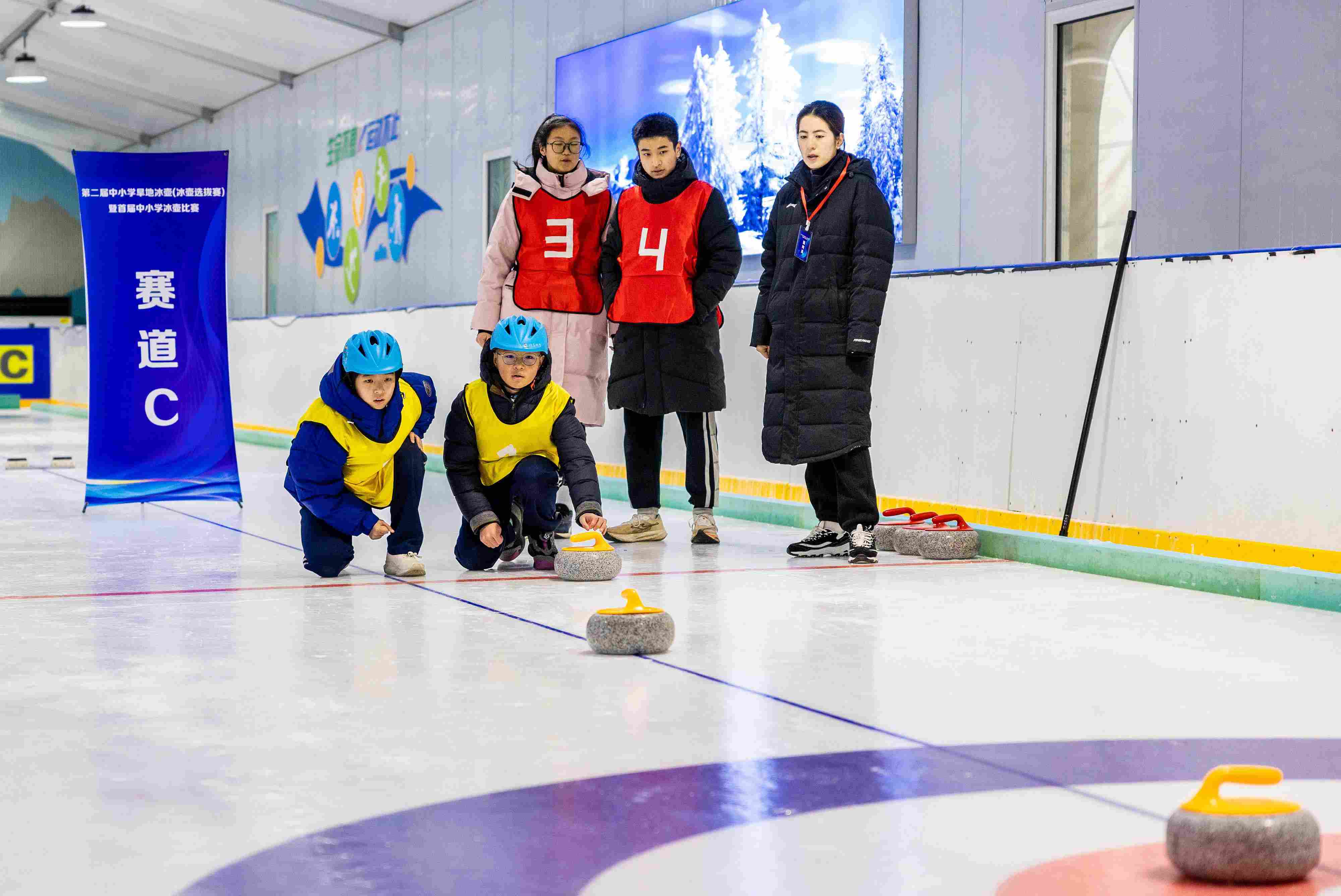 2023年12月10日，參賽選手在呼和浩特首屆中小學(xué)冰壺比賽中投擲冰壺。