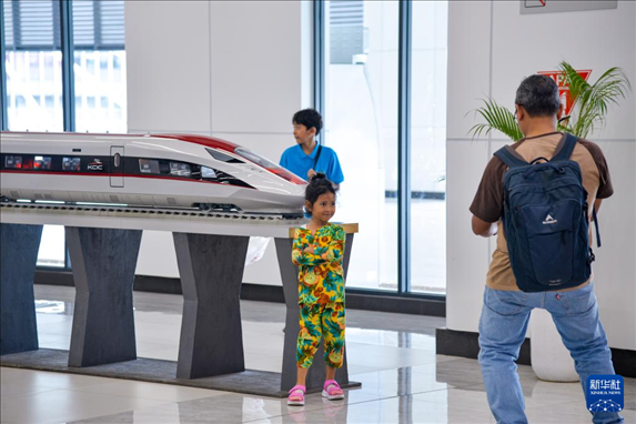 1月24日，在印度尼西亞雅加達(dá)哈利姆站候車大廳，一名小朋友和雅萬(wàn)高鐵高速動(dòng)車組模型合影。新華社記者 徐欽 攝