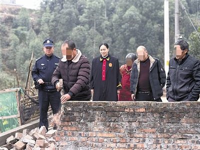  圖③：庭審結(jié)束后，在法官的見證下，陳某在院壩邊重新開鑿一條通道。