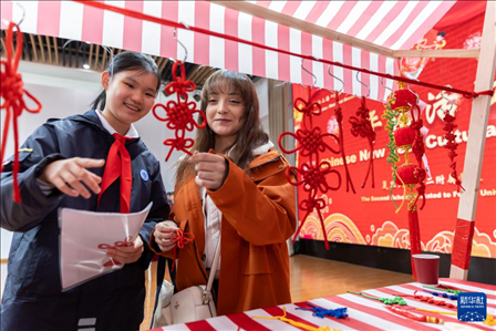 1月28日，復(fù)旦大學(xué)第二附屬學(xué)校學(xué)生（左）為美國(guó)馬斯卡廷中學(xué)學(xué)生（右）介紹中國(guó)結(jié)。 新華社記者 王翔 攝