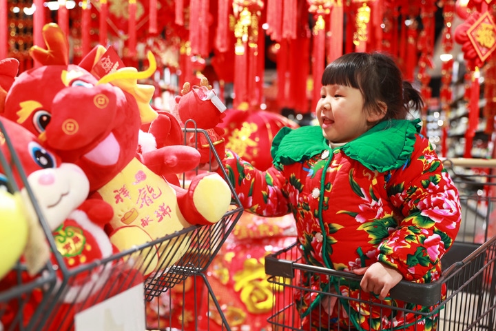 1月23日，在貴州省黔東南苗族侗族自治州岑鞏縣一家超市，小朋友在家人的帶領(lǐng)下選購龍年毛絨玩具。新華社發(fā)（唐鵬攝）