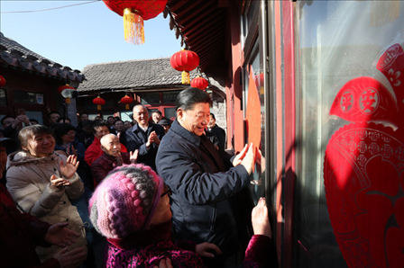 2019年2月1日上午，習近平總書記在前門東區(qū)草廠四條胡同32號院，高興地拿起一幅“?！弊?，親自貼到門上，給這里的老街坊們拜年。新華社記者鞠鵬攝