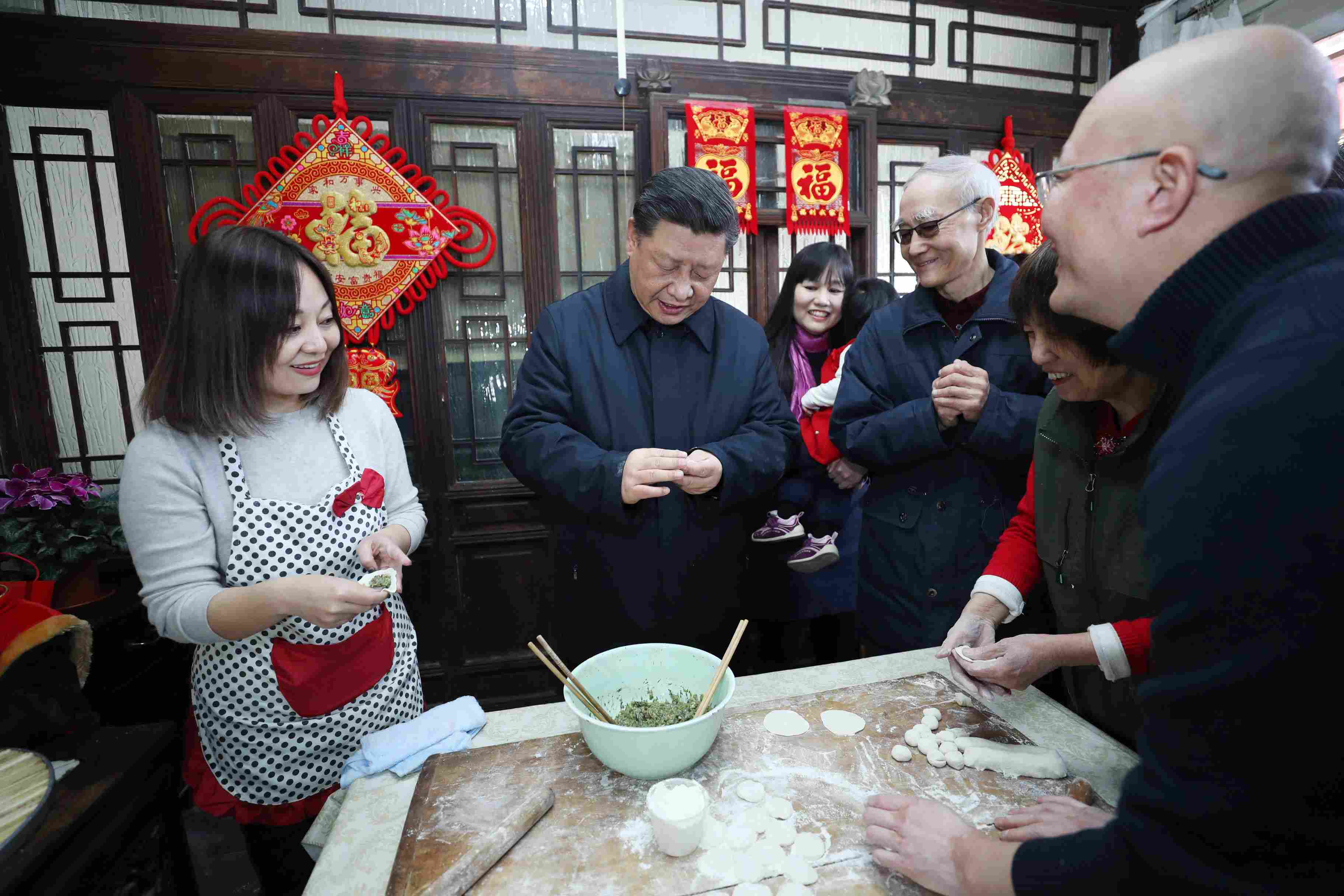 △ 2019年2月1日，習近平總書記在北京前門東區(qū)草廠四條胡同，同朱茂錦一家人包餃子、聊家常。