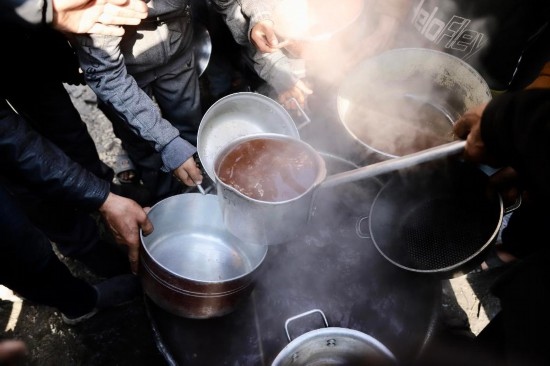 2月27日，在加沙地帶北部的杰巴利耶難民營(yíng)，人們領(lǐng)取食物。新華社發(fā)（穆罕默德·阿里攝）