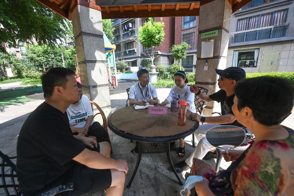 △2023年7月21日，在位于浙江杭州臨安區(qū)錦南街道水岸陽光小區(qū)的陽光議事廳，街道干部在聽取居民們反映的問題及意見。