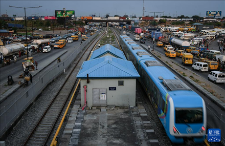3月4日，在尼日利亞拉各斯，一列輕軌藍(lán)線列車行駛至公路交通擁堵路段附近。新華社記者 韓旭 攝