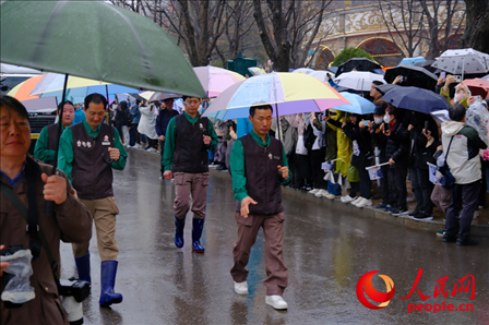 飼養(yǎng)員姜哲遠(yuǎn)和宋永寬為“福寶”開路送行。人民網(wǎng) 李帆攝
