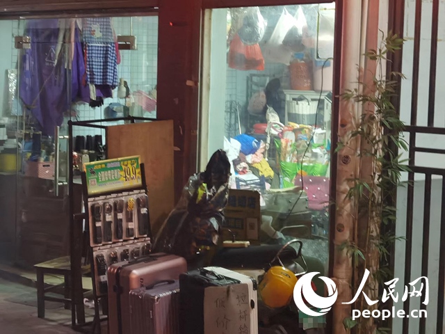 南寧“城中村”一裁縫鋪老板將電線從店內(nèi)拉出為電動自行車充電。人民網(wǎng) 覃心攝