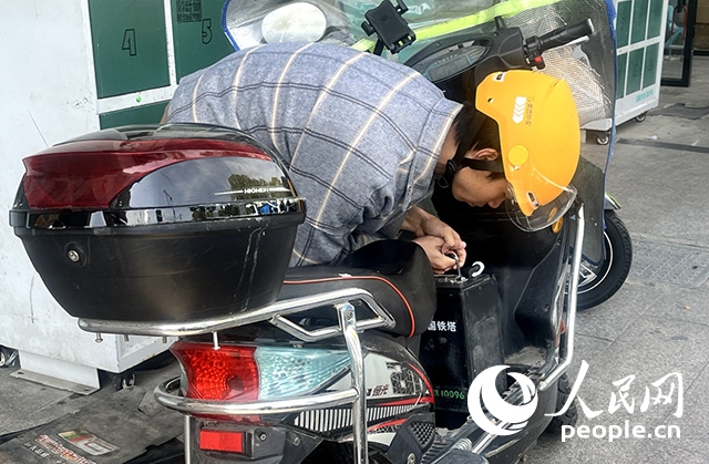 杭州一名外賣騎手正在更換共享電池。人民網(wǎng)記者 張麗瑋攝