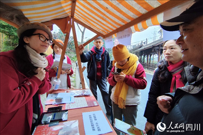 1月6日，“2024成都蒲江柑甜采摘節(jié)”上，記者見到了小萌（左一）和許多年輕人忙著做訪客接待、現(xiàn)場布置、票務(wù)核對、采摘服務(wù)等工作。人民網(wǎng)記者朱虹攝