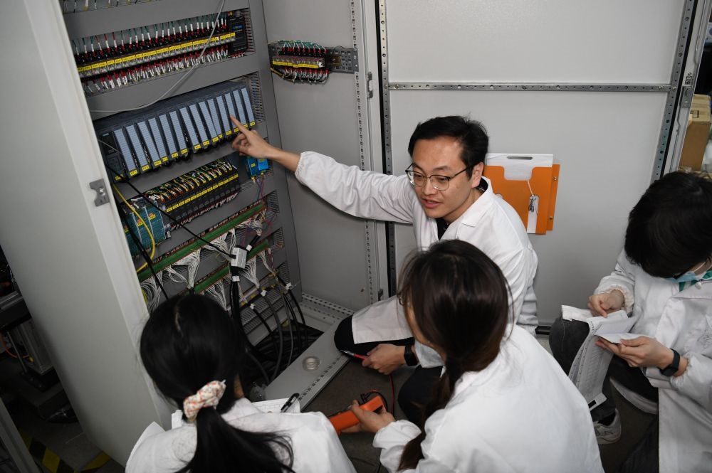 2024年4月6日，在位于安徽合肥的中國科學(xué)技術(shù)大學(xué)，安徽省先進功能高分子薄膜工程實驗室團隊成員在檢修自主研制的高分子薄膜原位雙向拉伸實驗設(shè)備的電氣控制系統(tǒng)。