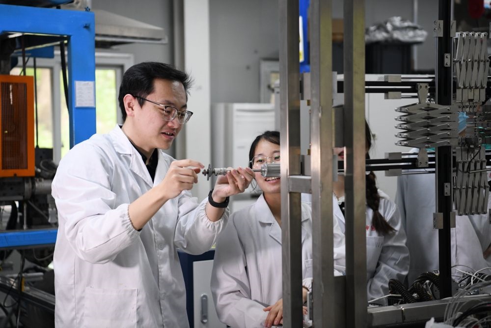 2024年4月6日，在位于安徽合肥的中國科學(xué)技術(shù)大學(xué)，安徽省先進功能高分子薄膜工程實驗室團隊成員朱健和（左）在和同事討論實驗設(shè)備的設(shè)計方案。