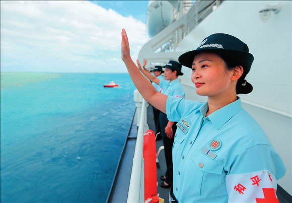 中國(guó)海軍“和平方舟”號(hào)醫(yī)院船結(jié)束訪問(wèn)湯加時(shí)，任務(wù)官兵中的文職人員向歡送人群揮手告別（2023年8月4日攝）。徐巍攝/本刊