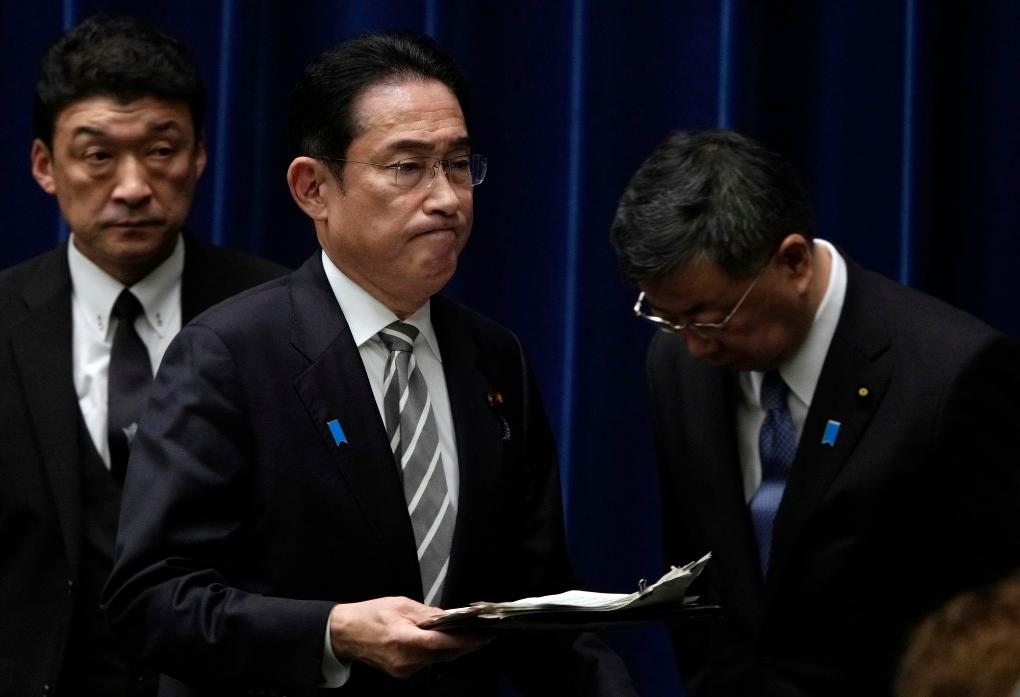 2023年12月13日，日本首相岸田文雄（中）在日本東京首相官邸召開(kāi)記者會(huì)后走過(guò)時(shí)任內(nèi)閣官房長(zhǎng)官松野博一（右）。新華社發(fā)（Pool圖片，弗蘭克·羅比雄攝）