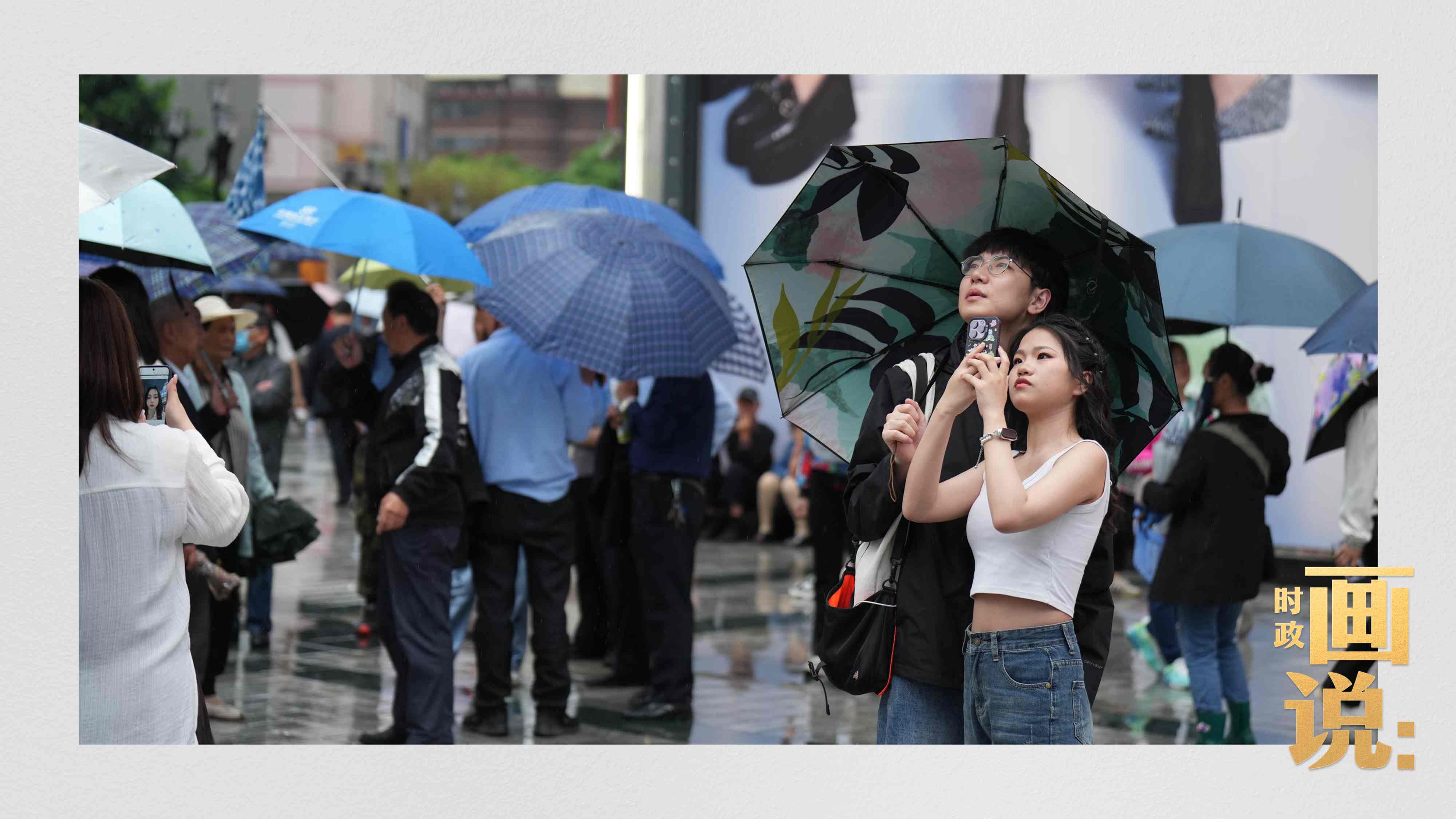 △細(xì)雨中的解放碑步行街，騎在父親肩膀的小女孩好奇張望。