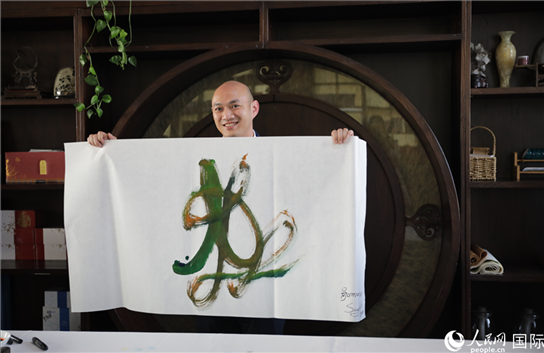 老撾駐華大使館三秘明君參加《五百筆·瀾湄合作》集體藝術(shù)創(chuàng)作。人民網(wǎng)王婧攝。