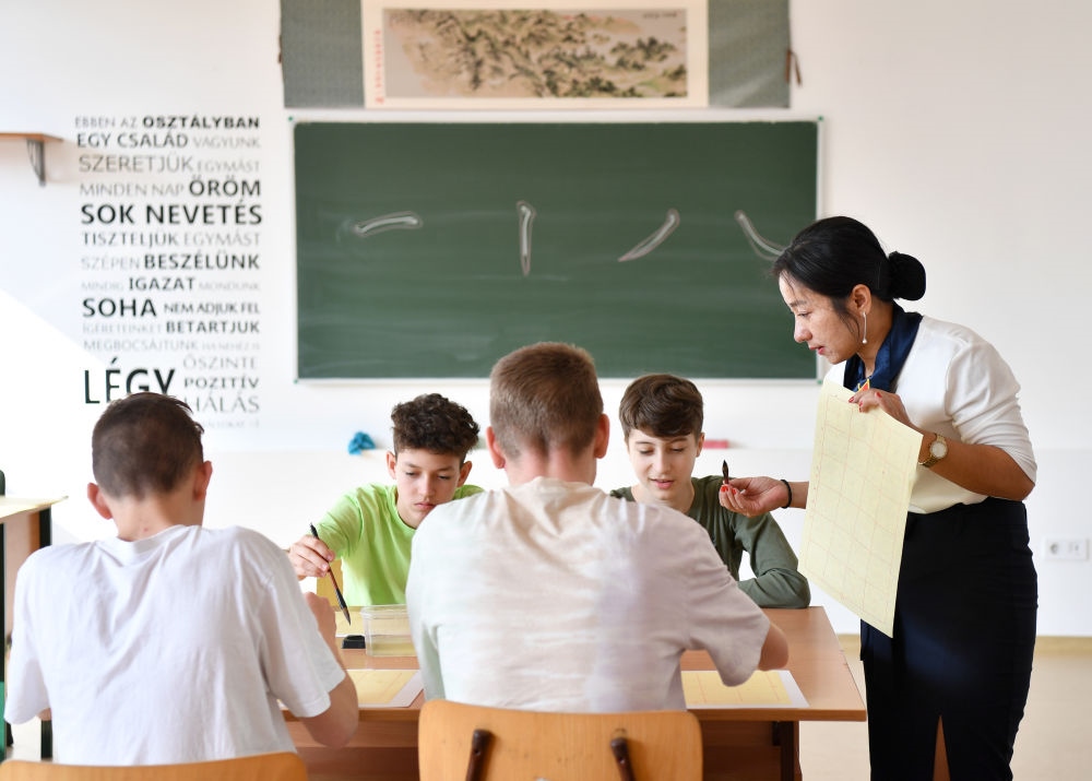 2023年2月24日，在匈牙利首都布達佩斯的匈中雙語學校，中國教師指導學生們學習書法。新華社記者 連漪 攝