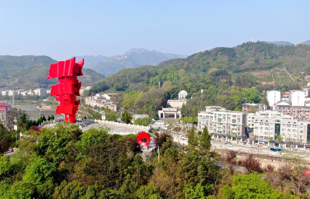 這是2021年4月9日拍攝的鄂豫皖蘇區(qū)首府革命博物館附近的英雄山上的“紅旗飄飄”主題雕塑（無人機(jī)照片）。新華社發(fā)