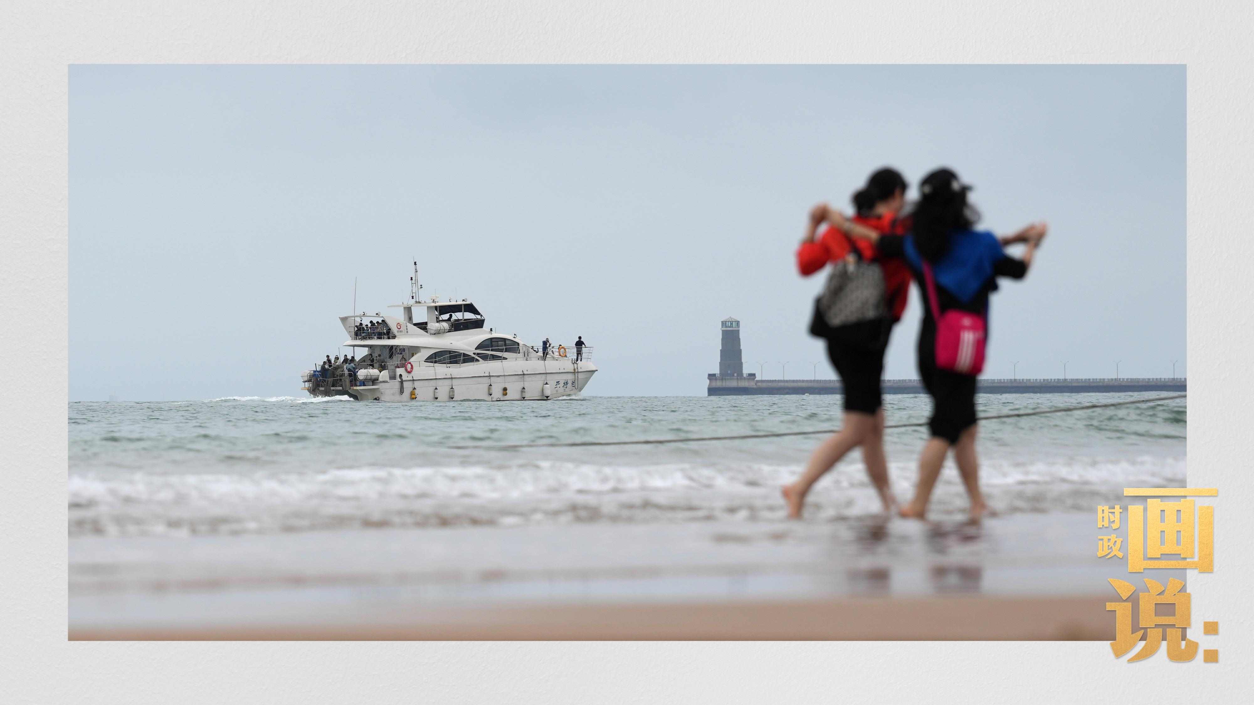 △日照陽光海岸綠道上的萬平口景區(qū)，一對游客在海浪中翩然起舞。