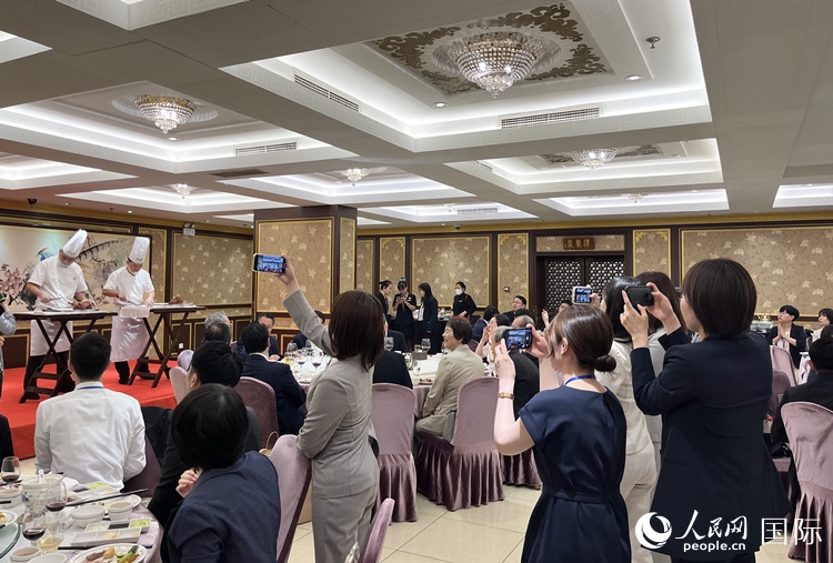 國家級非物質(zhì)文化遺產(chǎn)、全聚德片鴨工藝吸引代表團成員拍照留念。
