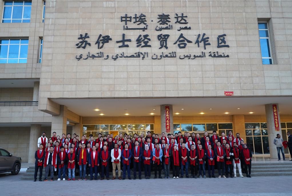2024年2月11日，在位于埃及蘇伊士省的中?！ぬ┻_(dá)蘇伊士經(jīng)貿(mào)合作區(qū)，中埃員工在合作區(qū)辦公大樓前合影拜年。新華社發(fā)（泰達(dá)合作區(qū)供圖）