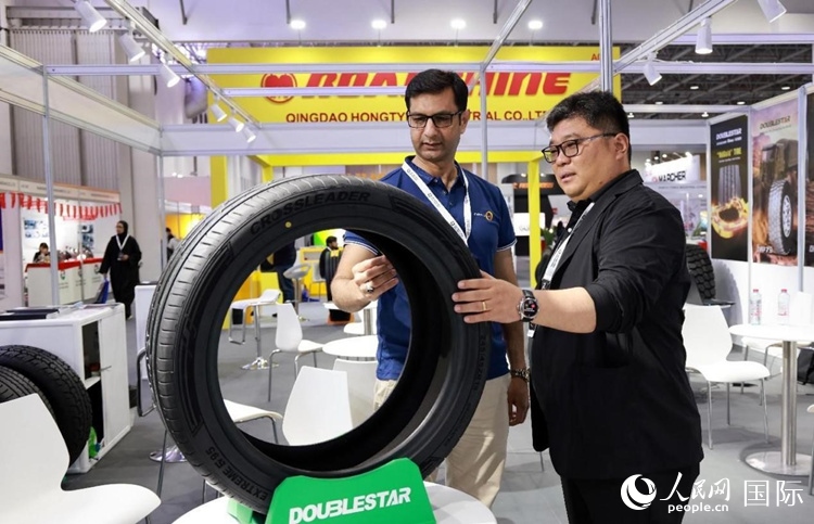 工作人員向客戶展示雙星電動汽車輪胎。和傳統(tǒng)汽車輪胎相比，電動汽車輪胎具有更高承載能力、更加靜音舒適、更好極速抓地、更低滾動阻力等特點。人民網(wǎng)記者 管克江攝