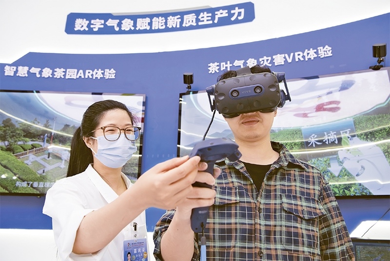 2024年5月23日，第七屆數(shù)字中國建設(shè)峰會現(xiàn)場體驗區(qū)在福州海峽國際會展中心向?qū)I(yè)觀眾開放。本次現(xiàn)場體驗區(qū)圍繞本屆峰會主題“釋放數(shù)據(jù)要素價值，發(fā)展新質(zhì)生產(chǎn)力”，設(shè)置“數(shù)字惠民”、“數(shù)字能力”、“數(shù)字基礎(chǔ)”、“數(shù)字生態(tài)”、“數(shù)字賦能”五大板塊。圖為一名觀眾（右）在數(shù)字氣象賦能新質(zhì)生產(chǎn)力展臺上進(jìn)行體驗。 新華社記者 魏培全/攝