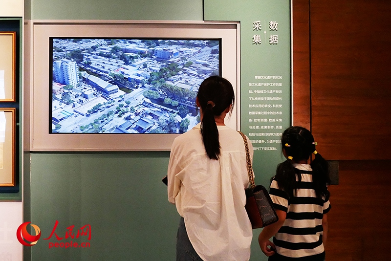 家長(zhǎng)正在帶孩子參觀“輝煌中軸”專題展。人民網(wǎng)記者 韋衍行攝