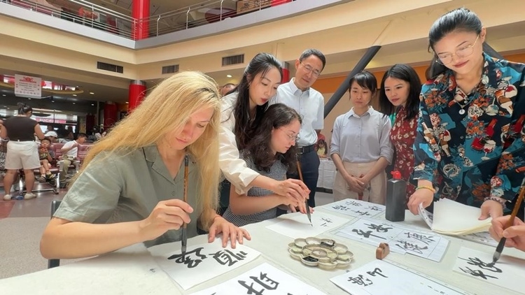 羅馬尼亞友人在活動現(xiàn)場學(xué)寫漢字。中國駐羅馬尼亞大使館領(lǐng)僑處供圖