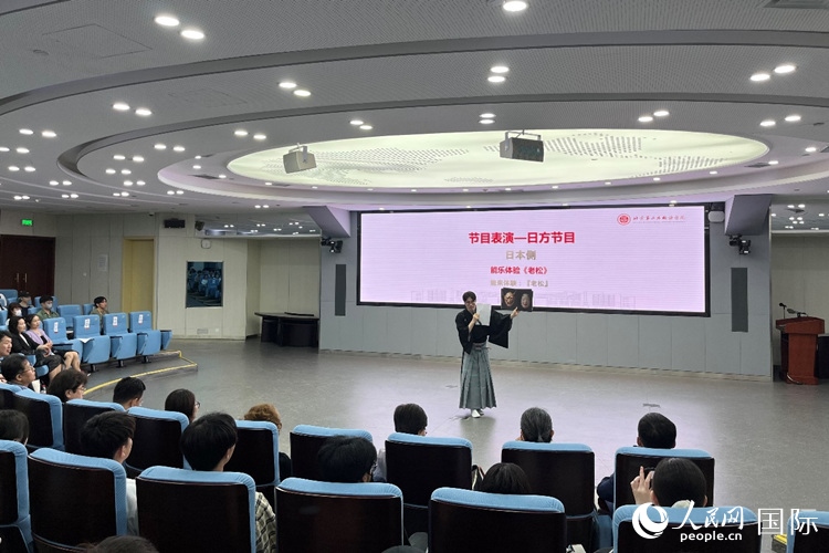日本大學(xué)生介紹能樂(lè)知識(shí)。人民網(wǎng)記者 陳思攝