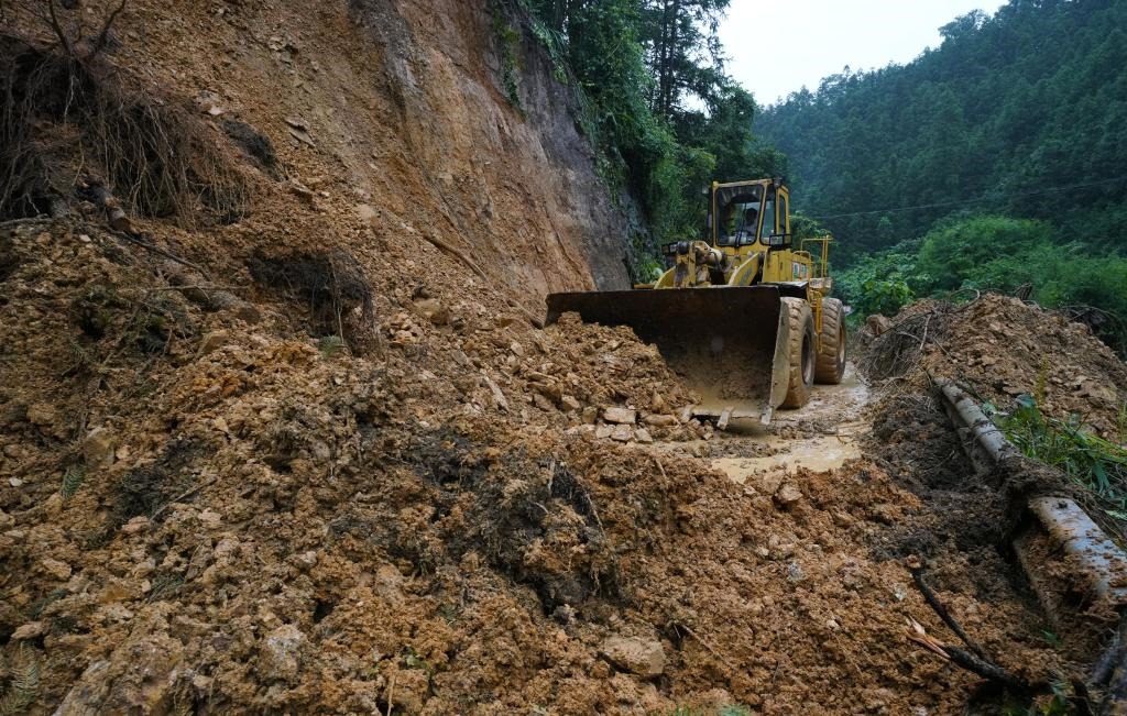 6月18日，在廣西融水苗族自治縣融水鎮(zhèn)新安村，一臺推土機在清理塌方路段。新華社發(fā)（龍林智攝）