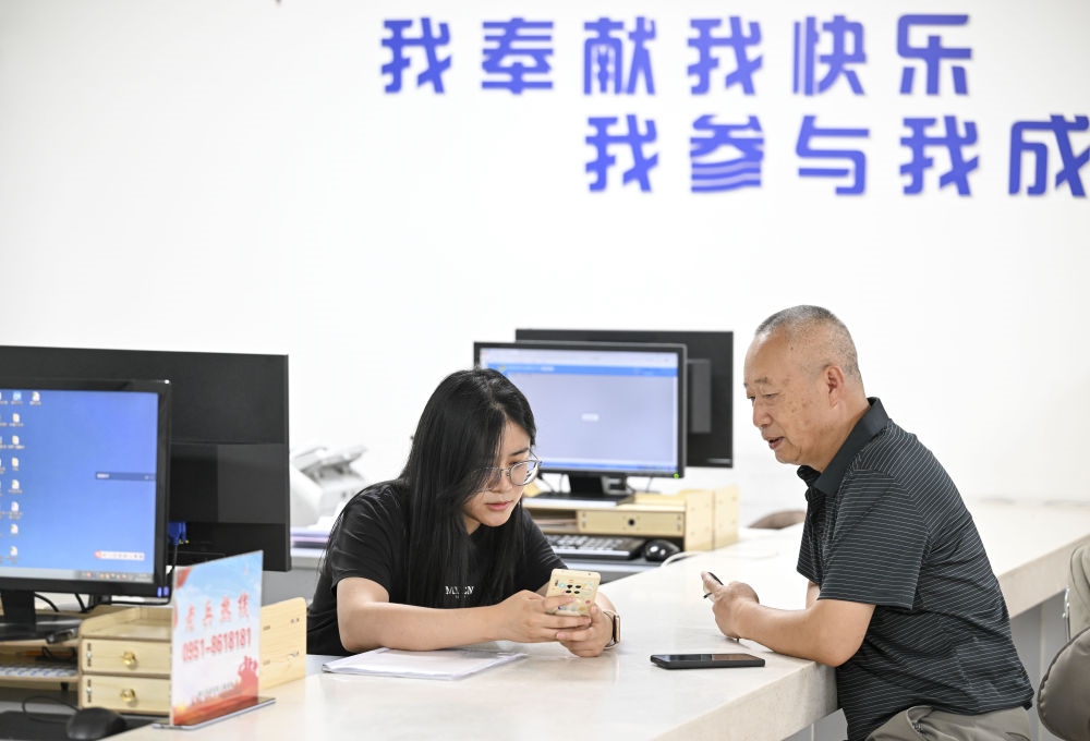 6月20日，在長城花園社區(qū)黨群服務中心，工作人員幫助居民辦理業(yè)務。