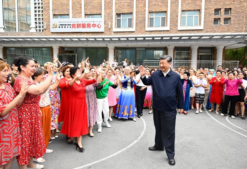2022年7月13日，習(xí)近平總書記在新疆烏魯木齊市天山區(qū)固原巷社區(qū)考察時(shí)，向各族群眾揮手致意。