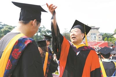 2017年6月22日，李德仁（右一）參加武漢大學(xué)畢業(yè)典禮并為畢業(yè)生撥穗。