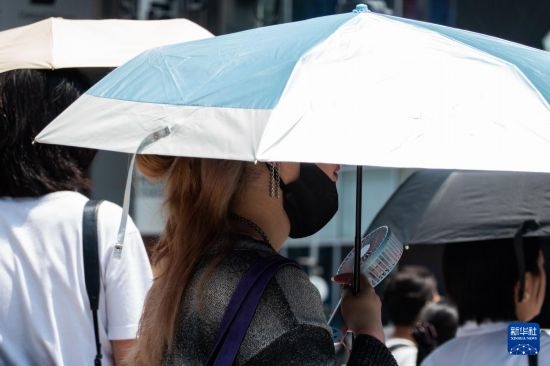 7月4日，人們?cè)谌毡緰|京原宿的街道上等待紅綠燈。新華社記者 張笑宇 攝