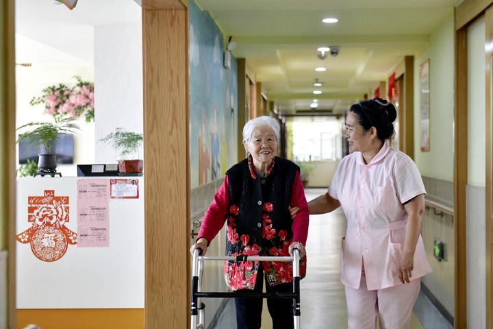 2024年5月25日，在山東省日照市東港區(qū)石臼街道日照幸福護(hù)理院，工作人員在陪護(hù)老人。新華社記者 郭緒雷 攝