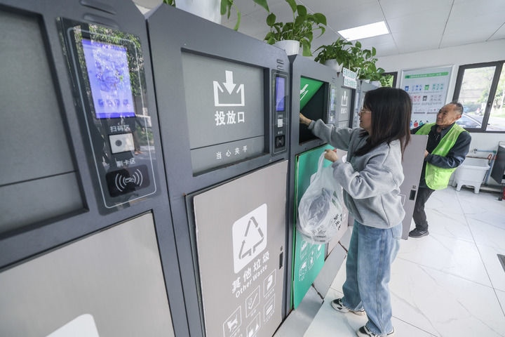 2024年4月10日，在浙江省湖州市吳興區(qū)飛英街道新華府小區(qū)內(nèi)，居民在垃圾分類智能系統(tǒng)的指導(dǎo)下進(jìn)行垃圾分類投放，居民的投放情況將實(shí)時(shí)匯總到智慧服務(wù)平臺(tái)，會(huì)有相應(yīng)的積分獎(jiǎng)勵(lì)。新華社記者 徐昱 攝