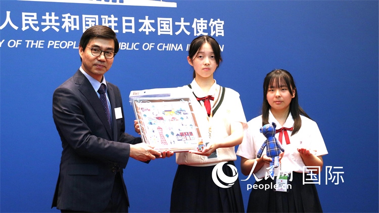 日本小大使向中國駐日本大使館臨時代辦施泳贈送當地特色禮品。人民網 許可攝