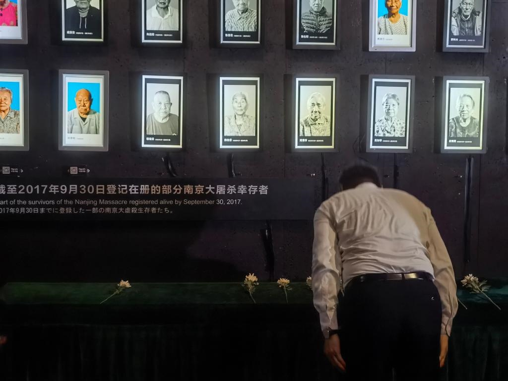 7月18日，人們向離世的南京大屠殺幸存者獻花、鞠躬。新華社記者邱冰清 攝