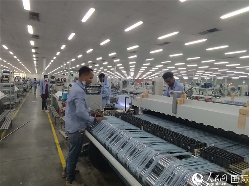 無錫金茂埃塞面料廠車間內(nèi)，當?shù)毓と苏谝唤z不茍地作業(yè)。人民網(wǎng)記者 黃培昭攝