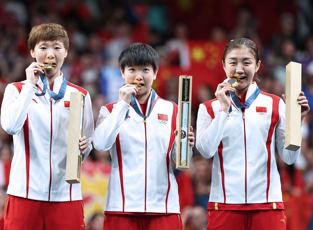 冠軍中國隊選手王曼昱、孫穎莎、陳夢（從左至右）在巴黎奧運會乒乓球女子團體頒獎儀式上（2024年8月10日攝）。新華社記者 王東震 攝