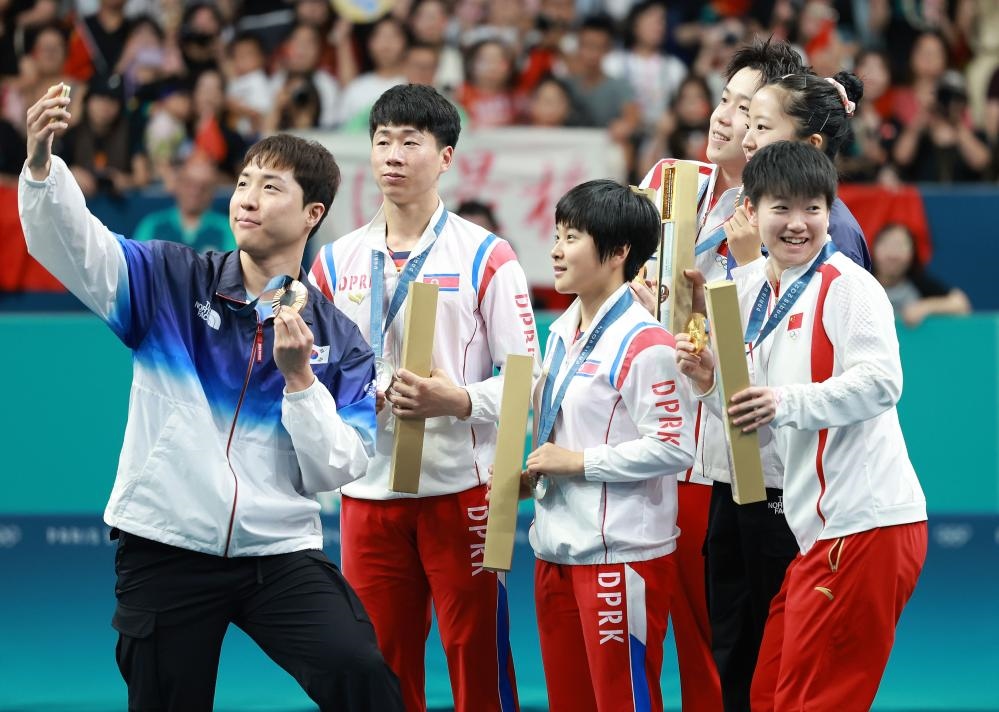 冠軍中國組合王楚欽（右三）/孫穎莎（右一）、亞軍朝鮮組合李正植（左二）/金琴英（左三）、季軍韓國組合林鐘勛（左一）/申裕斌在巴黎奧運會乒乓球混雙頒獎儀式上合影（2024年7月30日攝）。新華社記者 劉續(xù) 攝