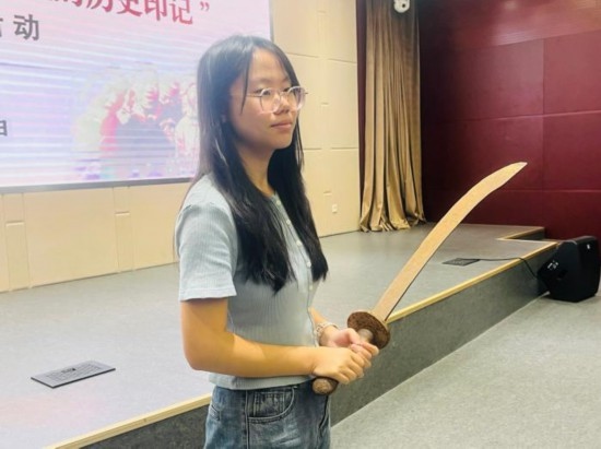 圖為南開(kāi)大學(xué)社會(huì)實(shí)踐隊(duì)學(xué)生代表呼月紅在學(xué)術(shù)交流活動(dòng)現(xiàn)場(chǎng)，展示河間調(diào)研行中獲贈(zèng)的一戰(zhàn)華工蔡世春曾使用過(guò)的一把大刀。林卓瑋 攝